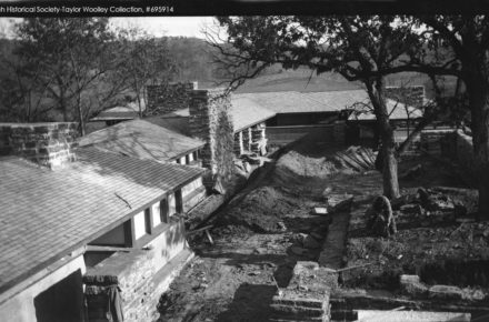 Photograph taken at Taliesin in late summer. The structure has been built, although not all of the windows are in. One man is bending working on teh ground.