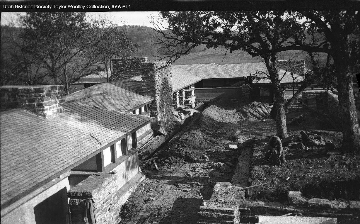 Photograph taken at Taliesin in late summer. The structure has been built, although not all of the windows are in. One man is bending working on teh ground.