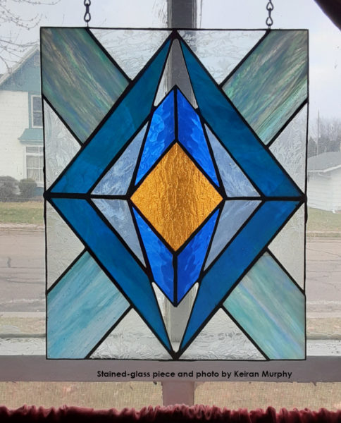 Looking at a blue and yellow rectangular stained glass piece.