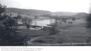 Black and white photo by Douglas Lockwood 1945-1949. Shows Taliesin estate with Upper dam and road. Arrow pointing at Upper dam.