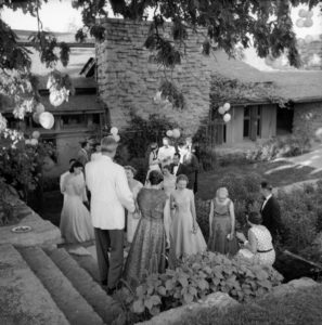 Exterior summer party at Taliesin in Wisconsin with men and women in formal dress.