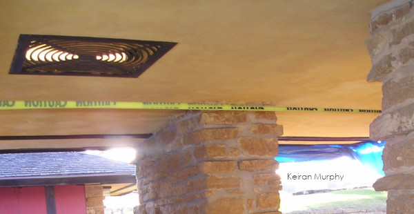 Looking (plan) south in Taliesin's Breezeway. In view: the lit ceiling grating, the top of the pier in the Breezeway; and a "caution" tape as Taliesin was under construction during Save America's Treasures in 2003-2004