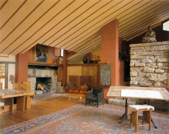 Taliesin studio with a drafting table, rug, fireplace, and artworks. Photograph by Judith Bromley. 