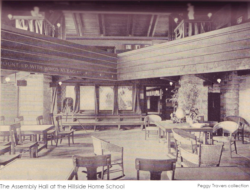 A black and white photograph of an assembly room at the Hillside Home School with wooden furniture and a wooden balcony on stone piers. From a school prospectus owned by Peggy Travers.